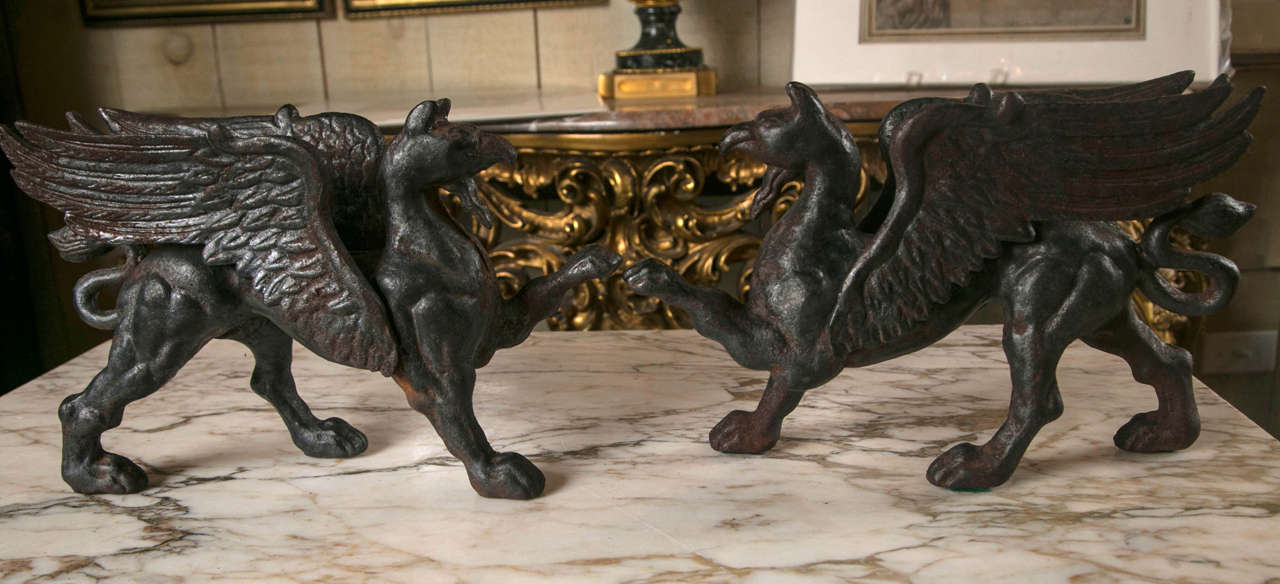 The pair of griffins  are each made in  halves, joined together with soldering. You can see the seam  on many of the photographs. Long wings, curving tail, raised front  left leg  and  defined muscles.