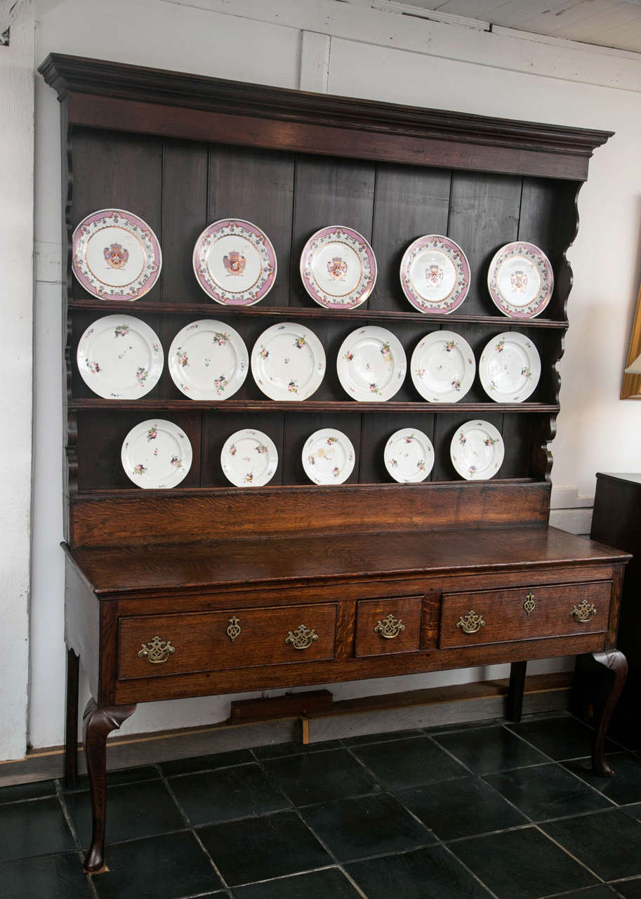 If ever there was a model Welsh dresser, this could be the one. The proportion of the rack to the base is exemplary from a time when these articles of furniture had reached near ubiquity. From the scalloped sides of the rack to the carved darts on
