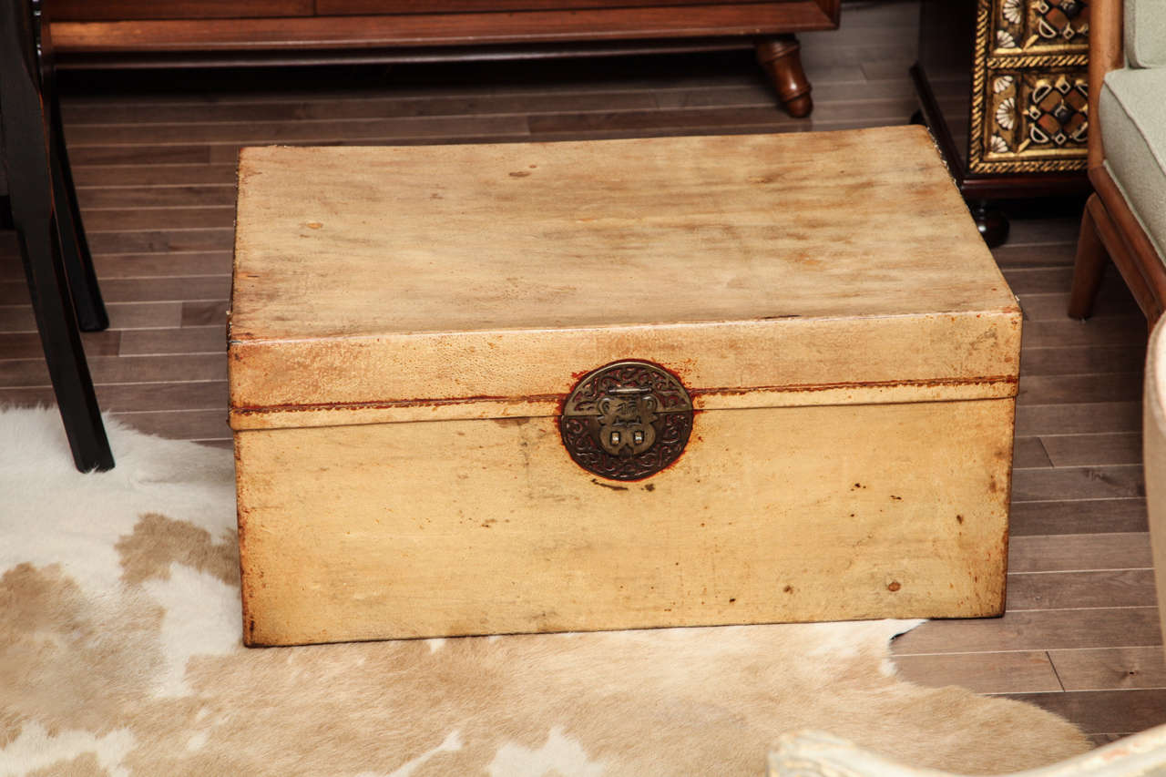 Tan leather Chinese trunk with red highlights and decorative brass hardware, c. 1920