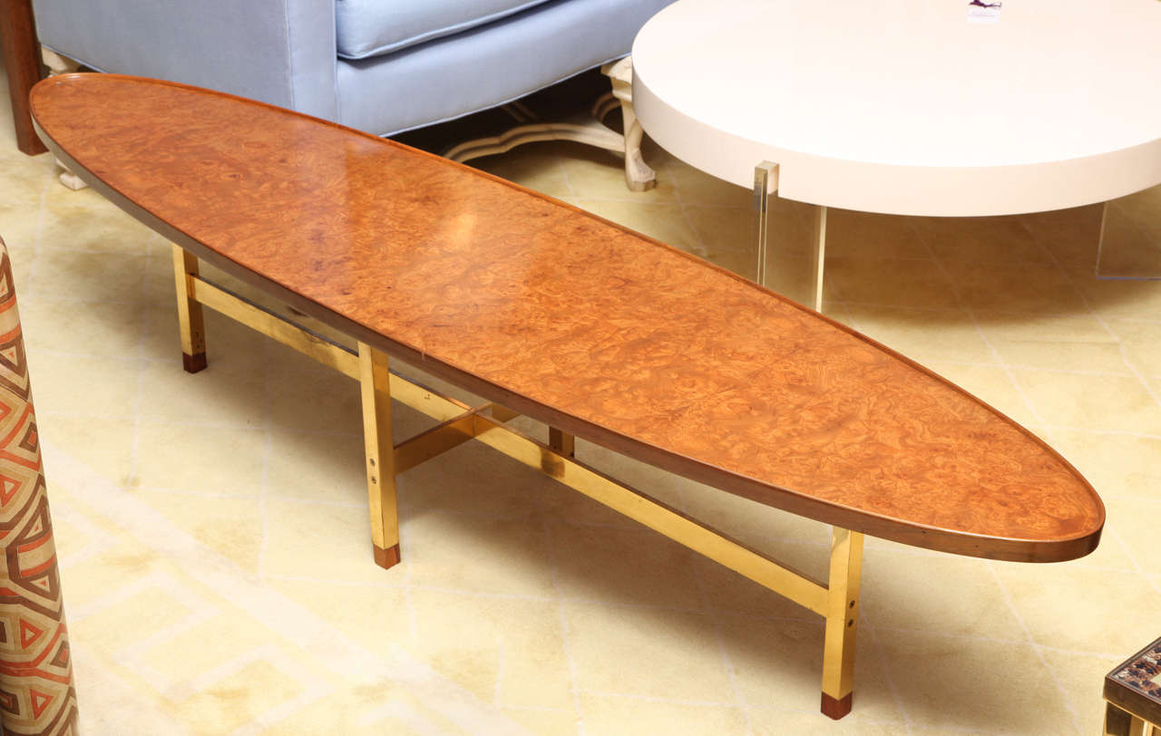 Edward Wormley low table in the form of a surfbaord with lipped edge and mirrored veneer top in burled Carpathian elm. Raised on a polished brass cruciform base with wood feet.
Executed by Dunbar
With Brass label and original order tag on