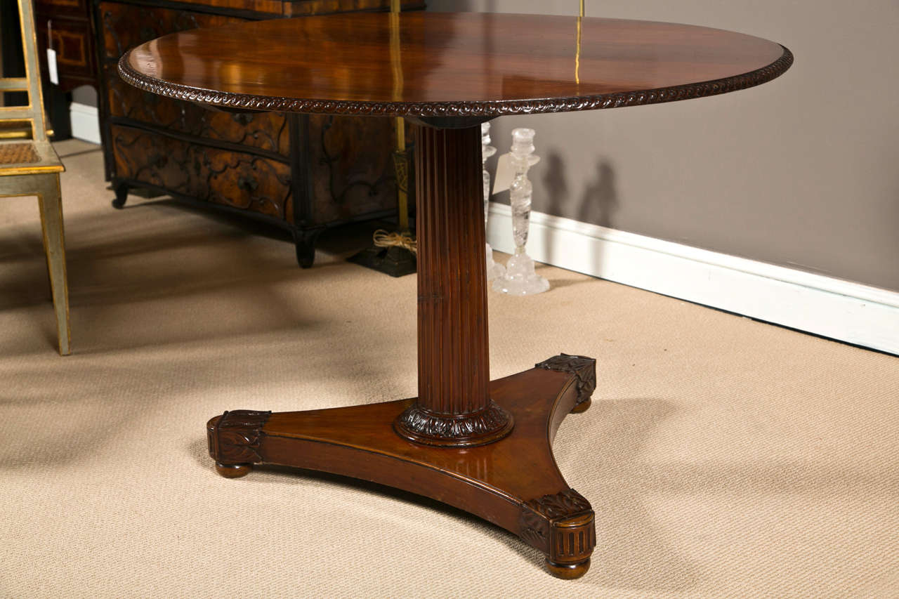 A late 18th early 19th Century Russian cherry wood tilt top center table with carved edge