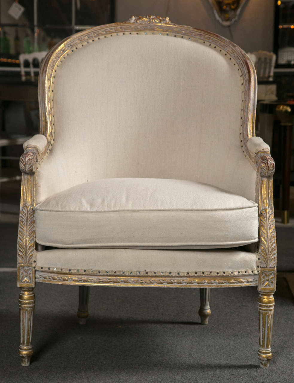 Pair of elegant and ample French bergere chairs in the Directoire style, circa 1940s with later upholstery, the fine quality and gorgeous grey blue painted and parcel gilt frame depicting patera and acanthus motifs, padded back and arms joint by