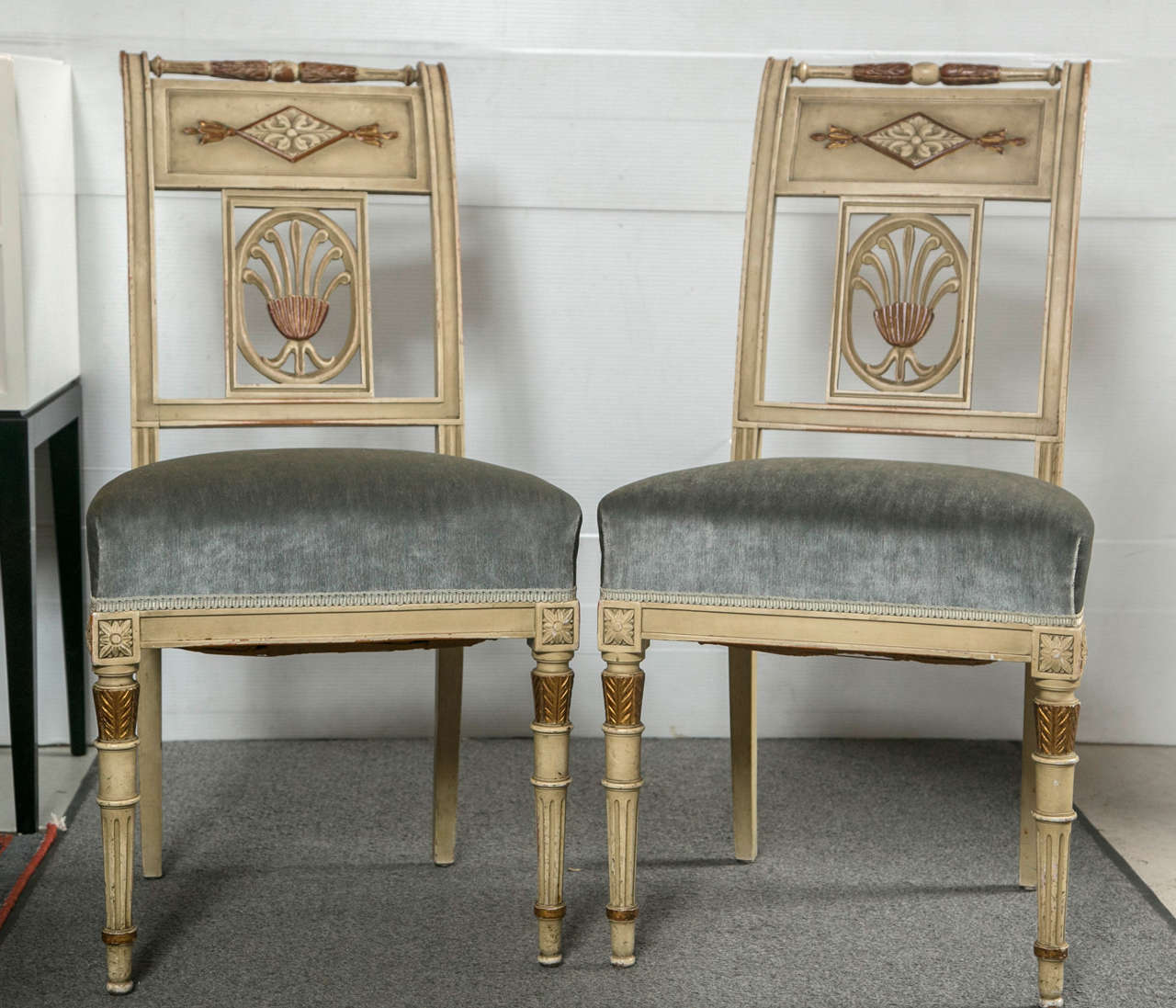 A fine set of six Hollywood Regency style dining chairs finely painted with gilt gold highlights. Each of these wonderful Maison Jansen chairs have tapering legs terminating in gilt capitals supporting a velour stuffed seat leading to square backs