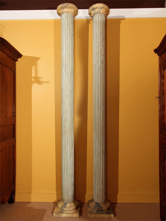 Pair of English Faux Painted Columns 

This pair of antique columns have faux marble doric capitals, fluted columns and square plinth bases. The marbling has cream to yellow tones and the fluting has azure blue to green coloring.