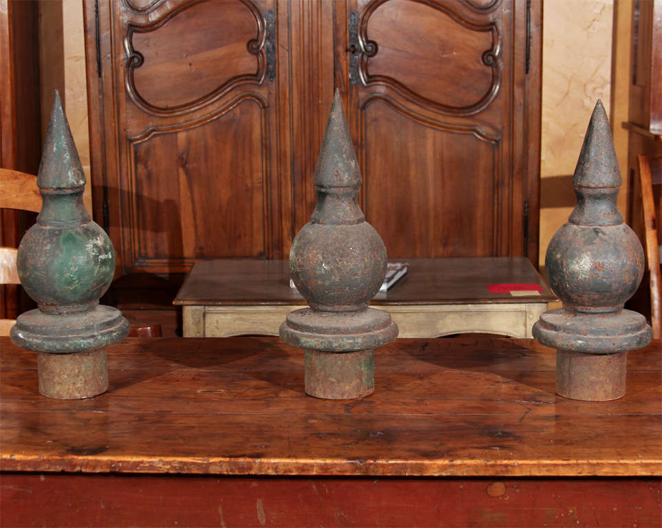 French Iron Finials

This is a collection of three iron finials from the top of fence posts.  They have been outside and have a beautiful weathered patina.  

They have been painted many times and the blue color is soft and warm.

They are