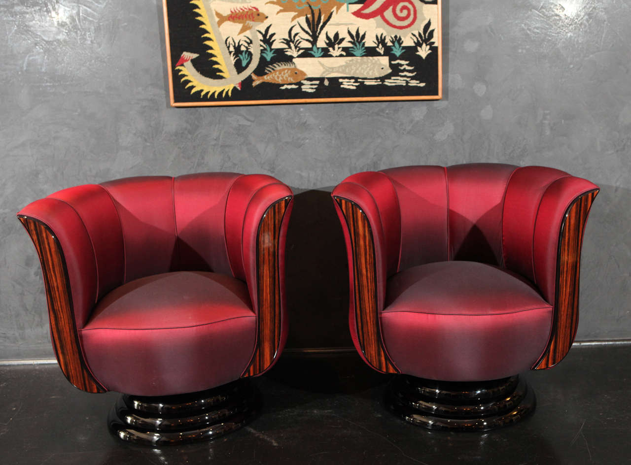 Pair of Tulip Swivel Chairs. Macassar arms and black lacquer base. Upholstered in red silk. Stunning conversational pieces.