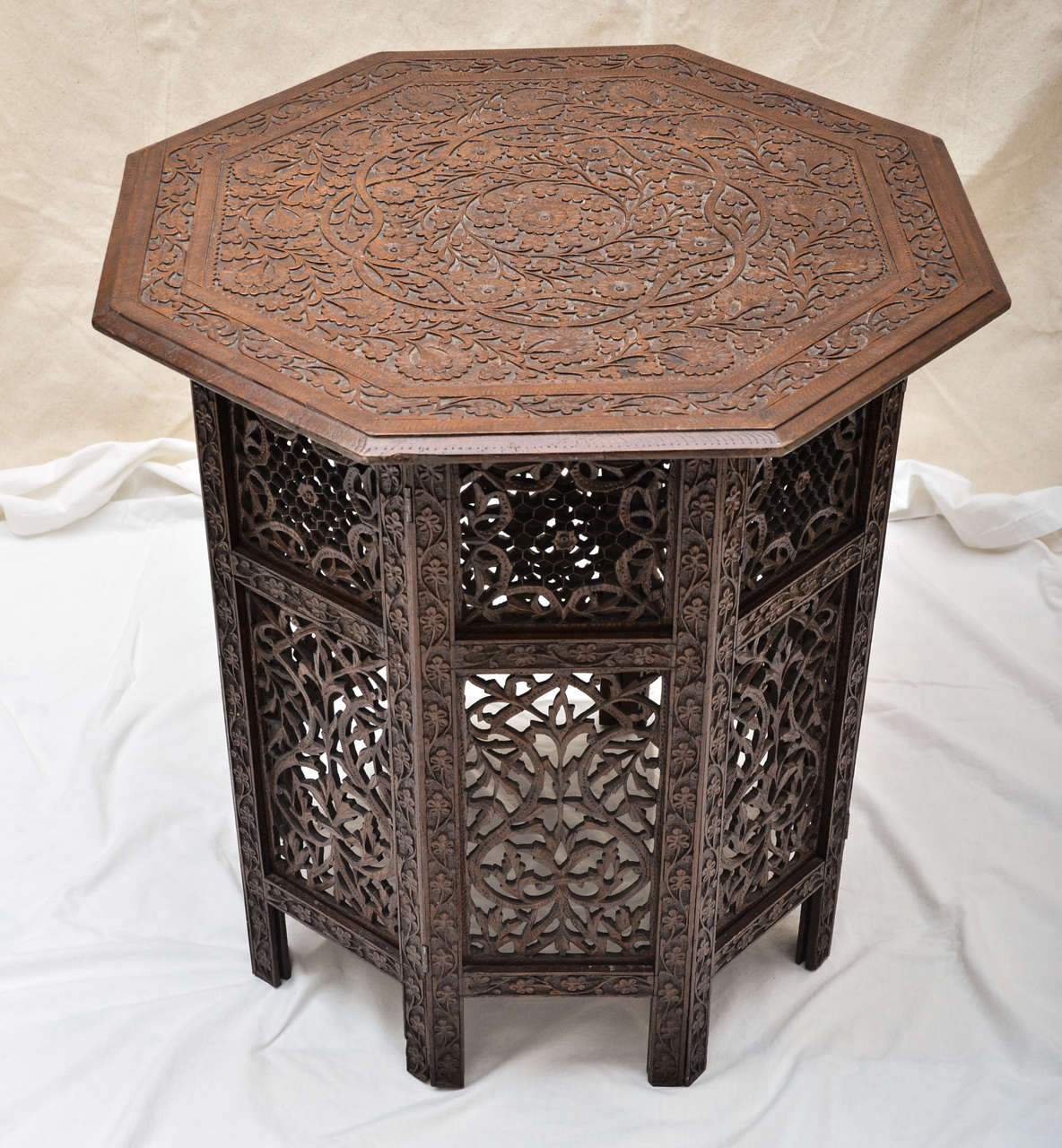 Octagonal Indian Teak Table with Mogul Style Carving to Top and Cut Out Floral Carvings to Sides. Great End Table or Bedside.