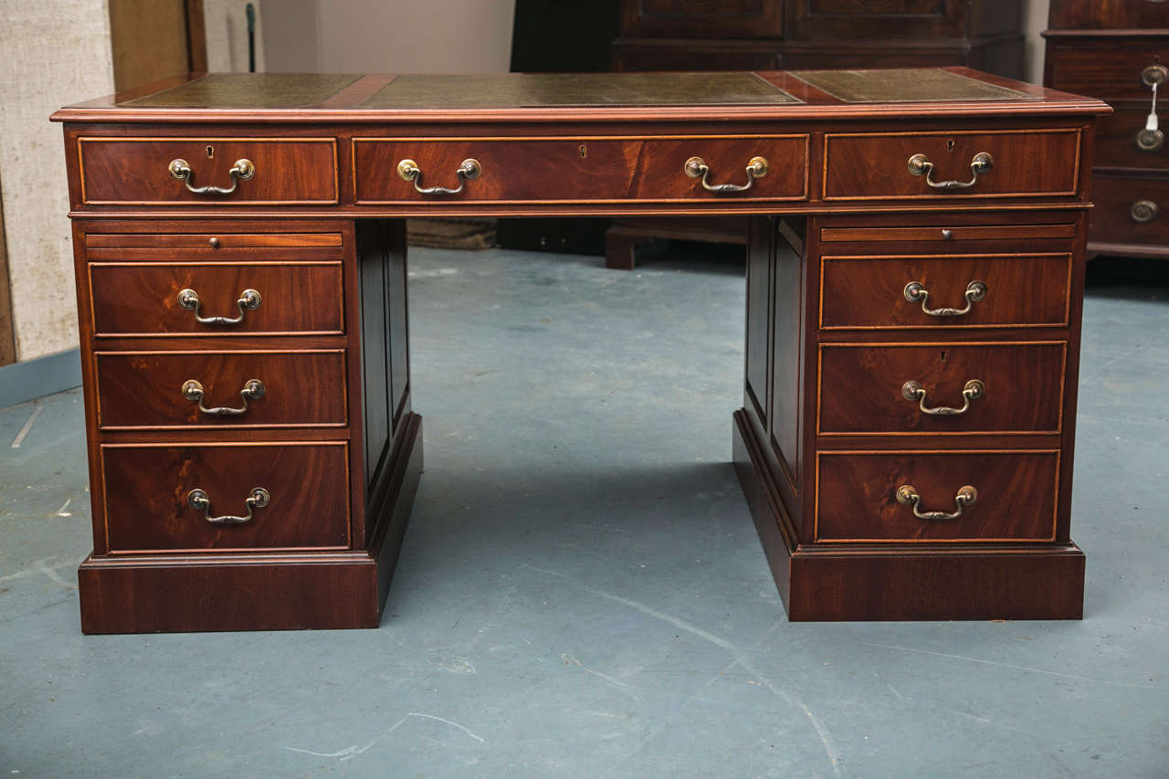 This Georgian styled desk with raised panel sides and three-piece leather top with gilded tooling is generously sized without being overly dramatic. At 60” by 36”, there is enough surface area to spread out without eating up too much valuable real