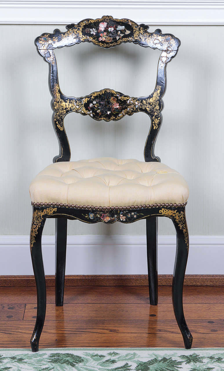 The lacquered frames with inlaid floral decoration and gilt foliage; raised on cabriole legs.