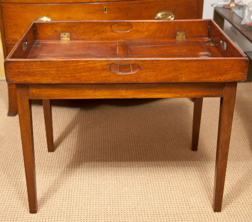 A Georgian solid mahogany folding butlers tray with brass hardware on a later mahogany stand.