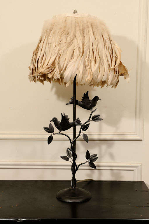 The base is metal with flexible leafs and birds. The shade is covered with light beige colored feathers to compliment the birds.