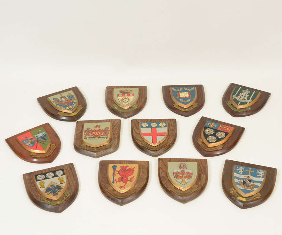 Set of Twelve English Collegiate Armorial Plaques with Hand-Painted Shields Mounted on Oak Bases Including Westmoreland, Somerset, Lancashire, and King's College, Cambridge.  England, mid 20th Century.

Each Plaque:  6 inches wide x 7 inches high