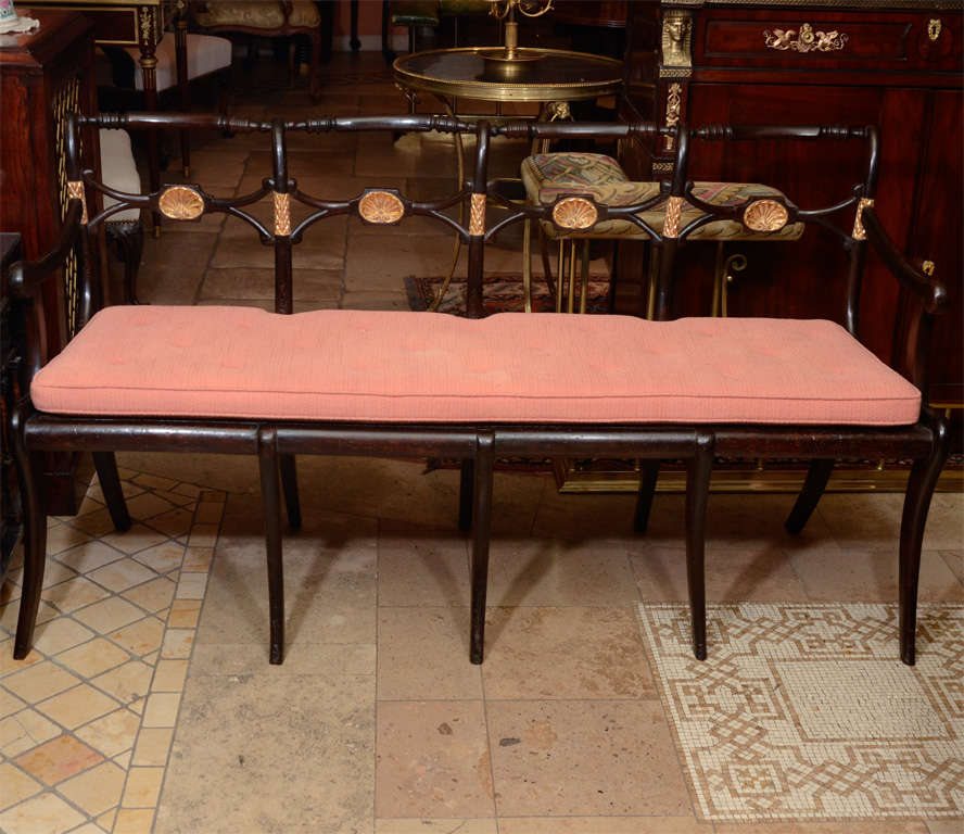 Rare and unusual Regency parcel gilt carved quadruple back caned bench with sabre legs and carved shells.