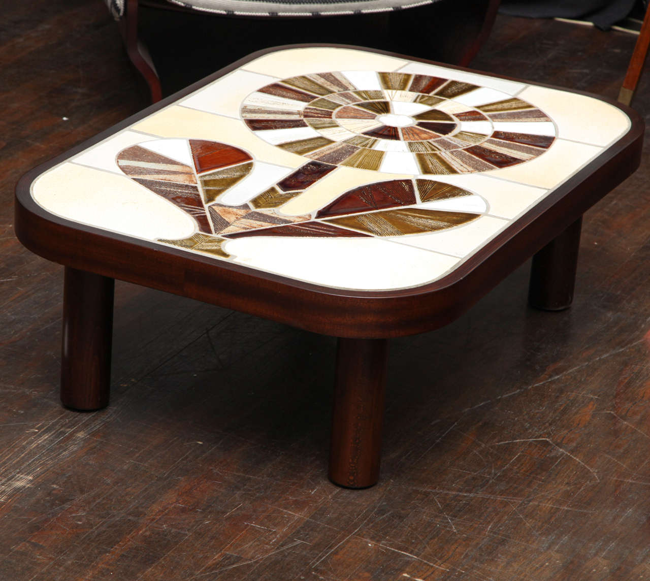 Handmade low table with great proportions. Walnut frame with rounded corners and ceramic design inset onto the top depicting a graphic flower. Signed in the ceramic.