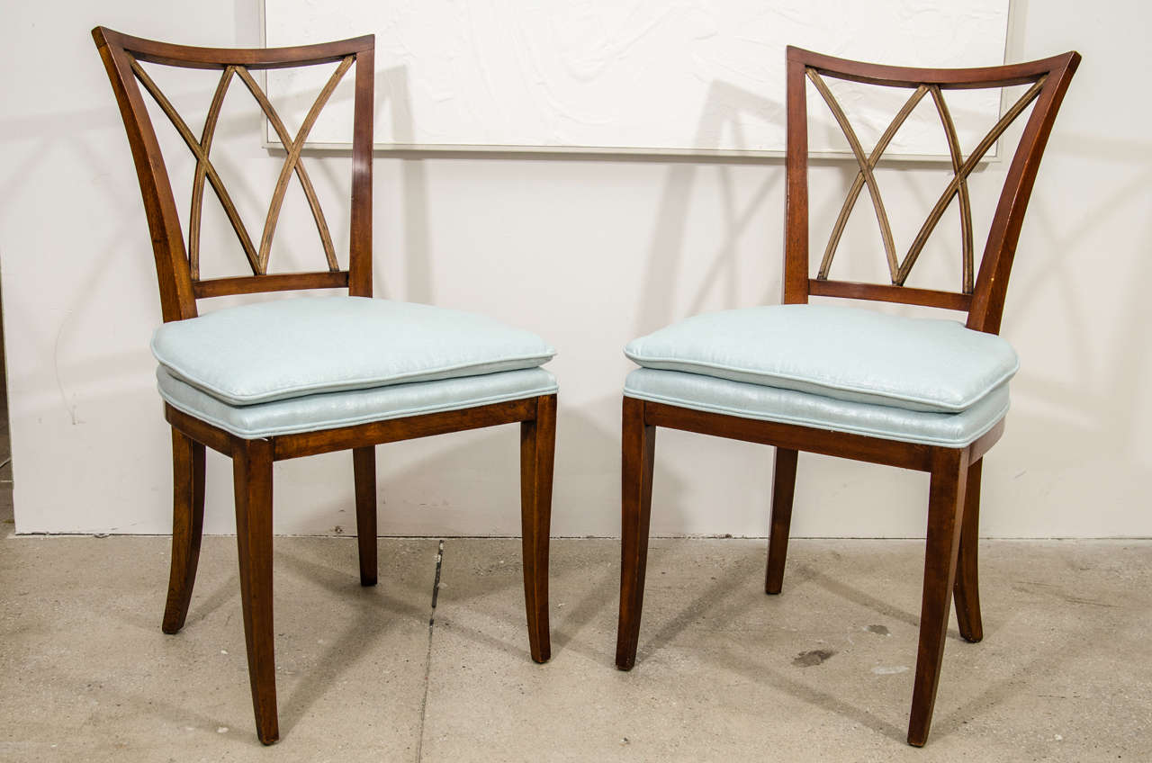 An elegant set of four fruitwood and parcel-gilt 19th century Continental side chairs. Seats have been re-upholstered in a glamorous metallic pale blue linen.