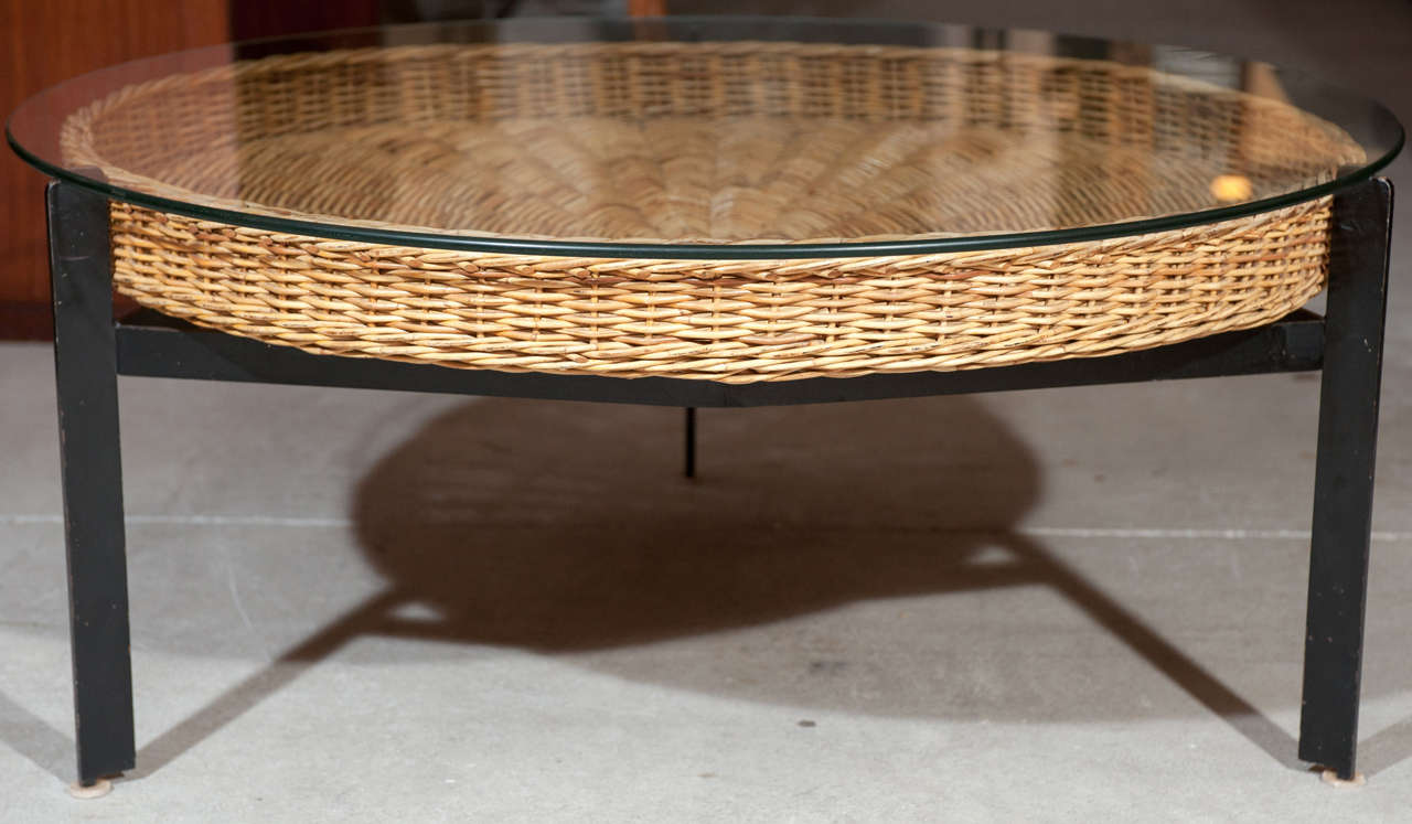 Black patinated metal coffee table with streamlined basket and floating glass top