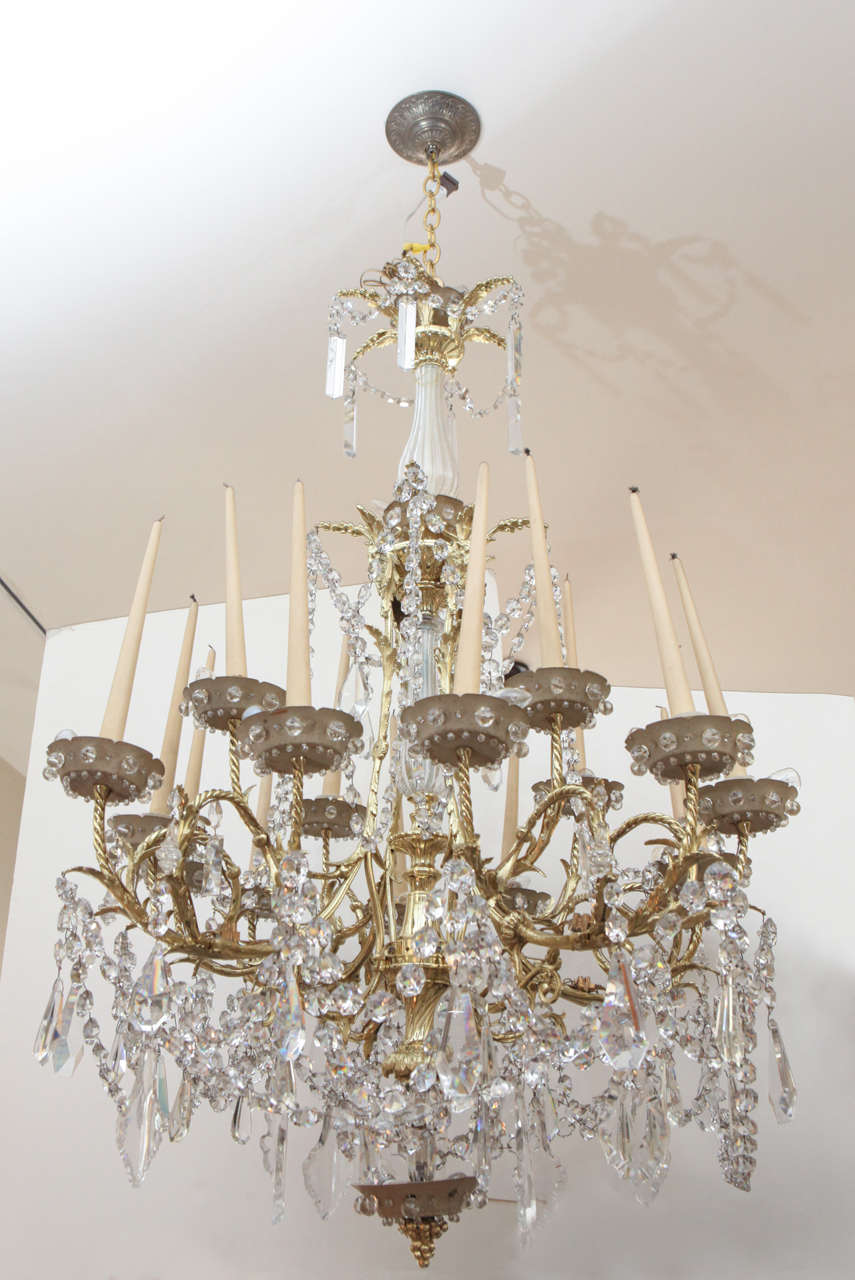 Uniquely designed Bagues chandelier with illuminated bobeches that cast a warm up-light to the wooden tapered faux candles. PLEASE NOTE: Parcel Delivery is not an option for this item. White Glove or Front Door Freight required.