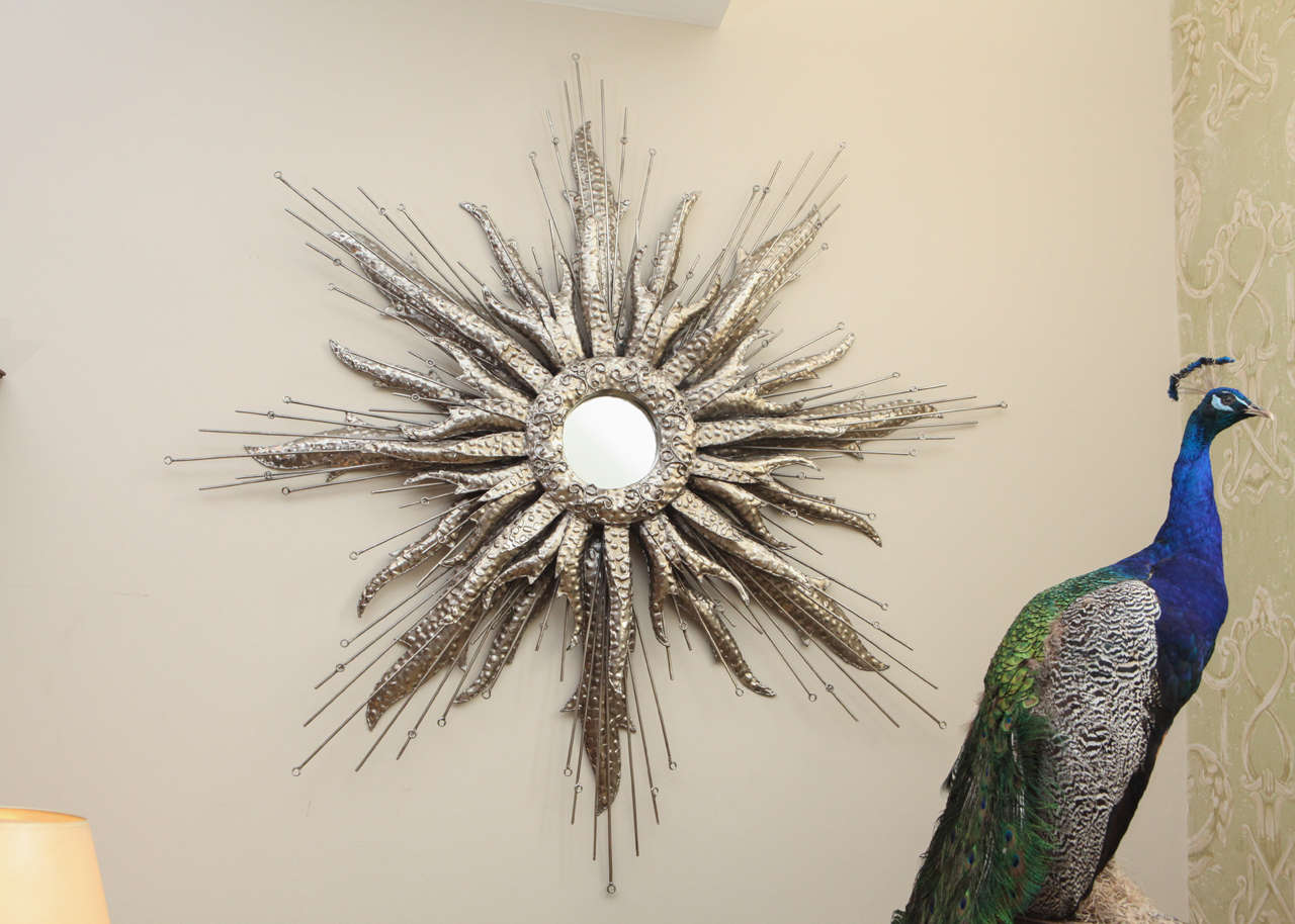 Large hammered silvered metal starburst with center mirror.
