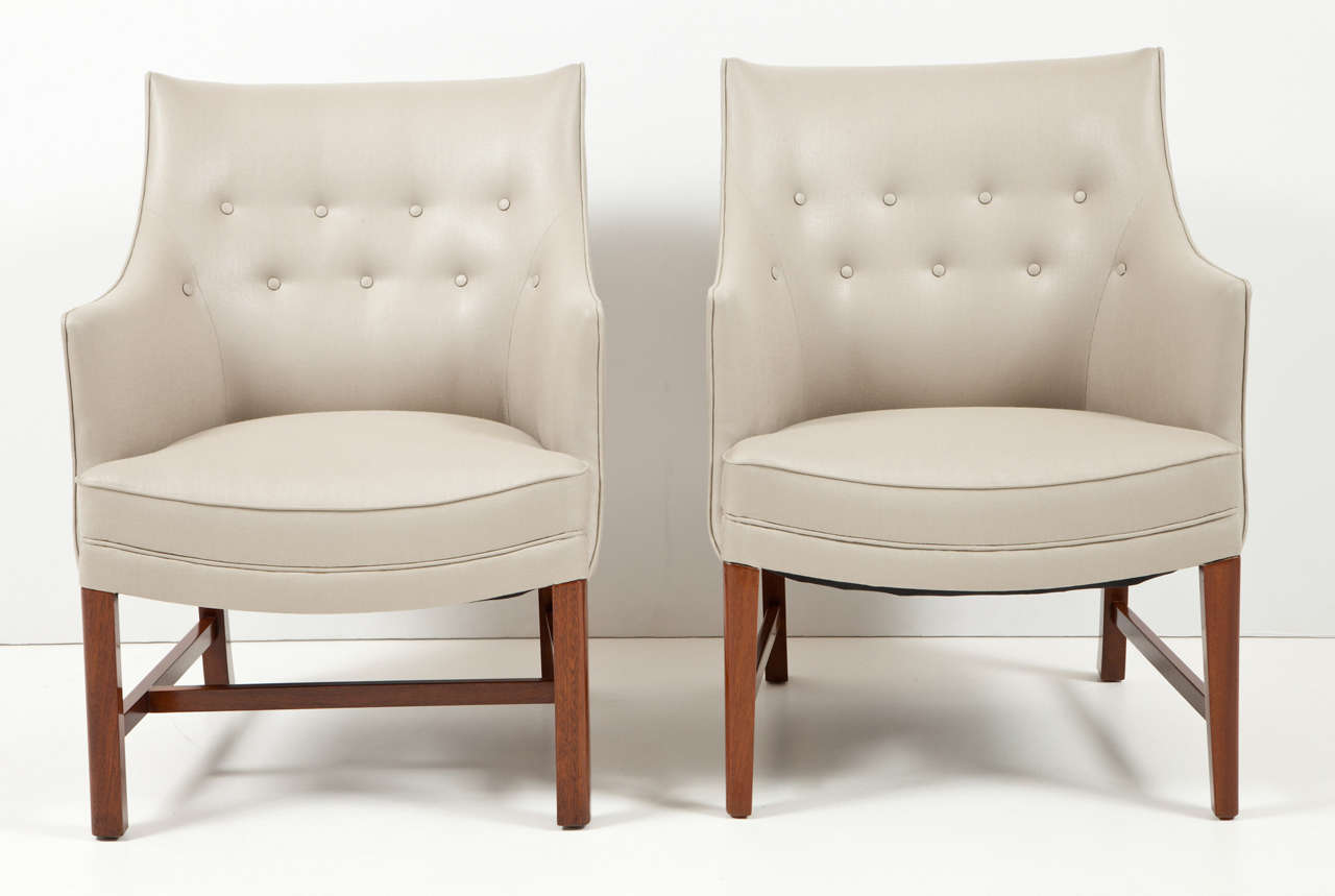 Two Frits Henningsen upholstered and mahogany framed armchair, circa 1940. With a curved backrests and downswept armrest raised on square legs joined by an H-form stretcher. Essentially the same chair but with a slight variation. One chair does not