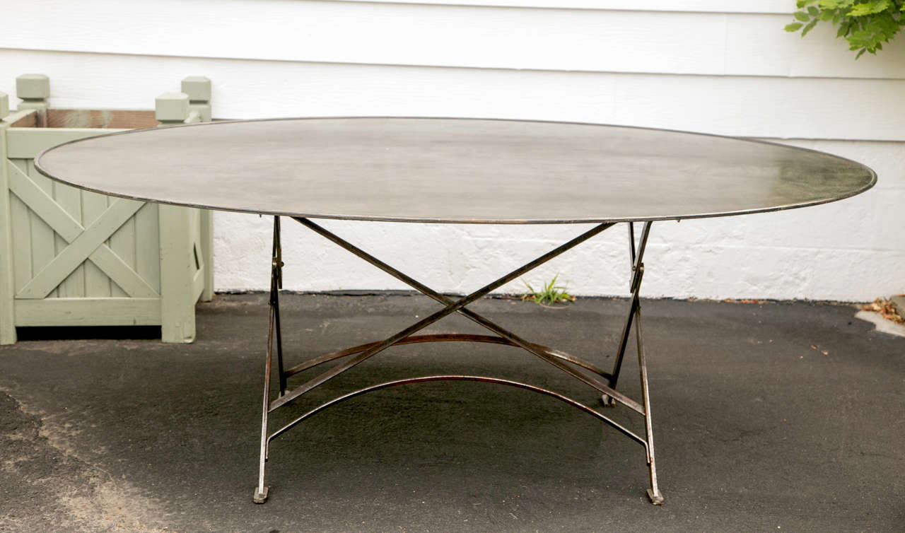 Imported from France folding metal table, wrought iron Campaign style, oval shape, gunmetal finish.