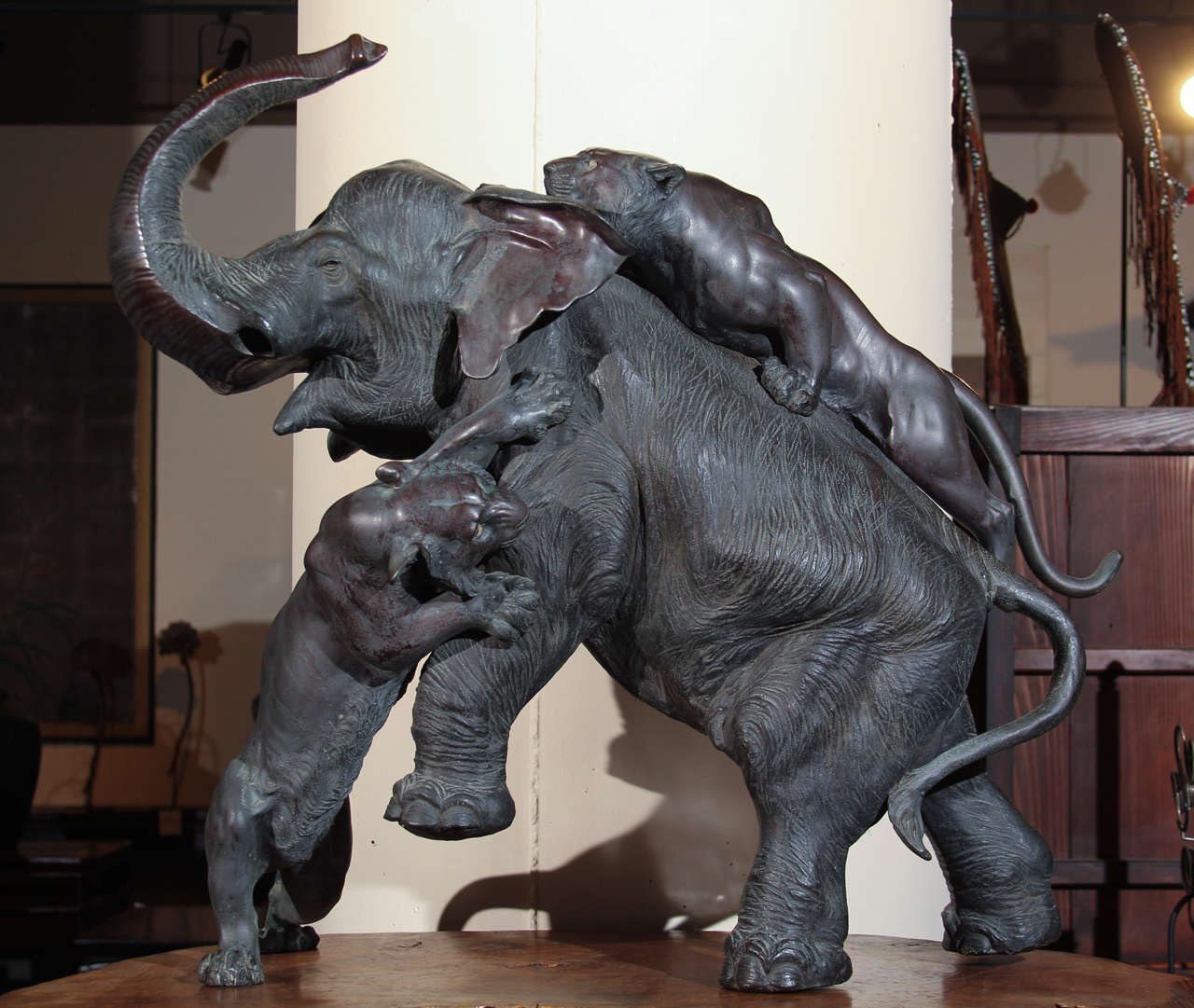 Finely detailed Japanese bronze sculpture of elephant with upturned trunk attacked by tigers. Natural lacquered wood Stand. 
Signed Genryusai Seiya, probably late 19th century.

Elephant: 40