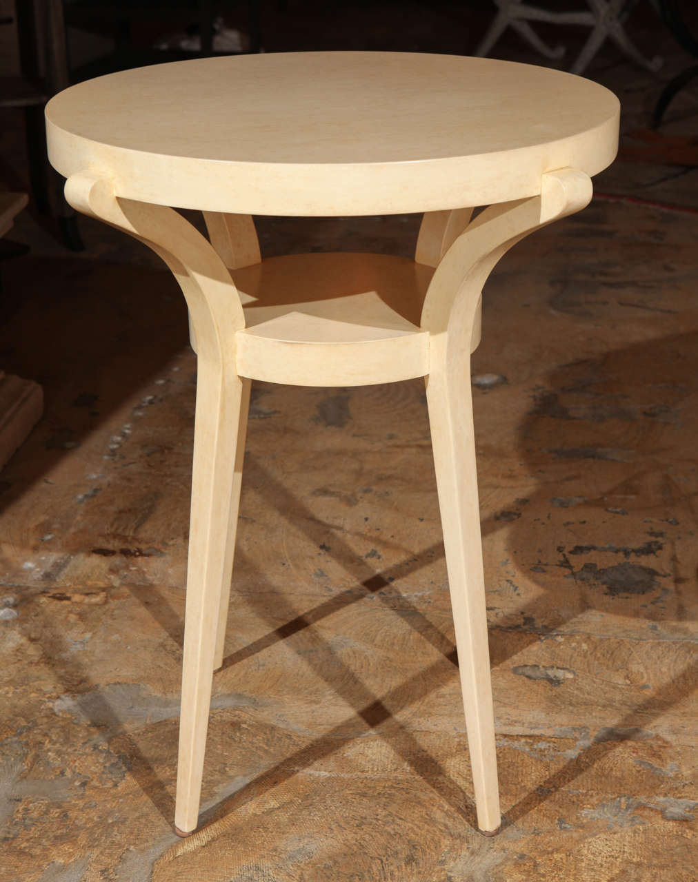 Modern restored sculptural side table in faux painted parchment finish over wood.
