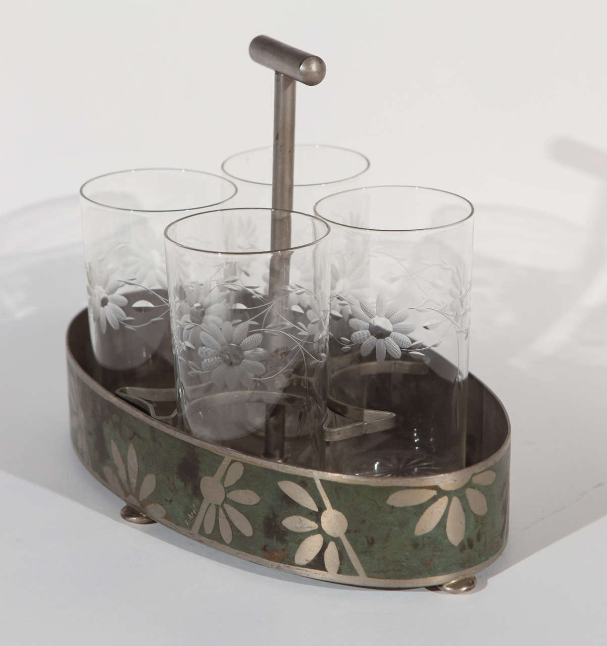 Art Deco Dinanderie aluminum caddy, circa 1920-1930, with four beverage glasses.