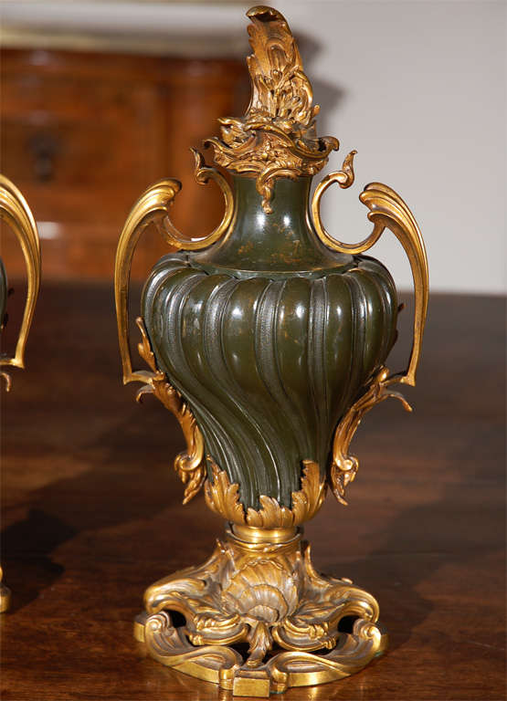 Pair of swirled, left and right, hard stone Russian urns with elaborates gilded bronze mounts featuring floral finials and pierced bases.