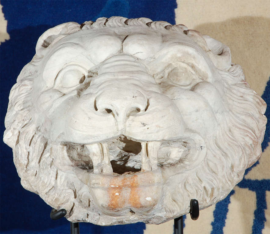 Stunning, solid white, Carrara marble lions head from a fountain in Florence featuring a flowing main and a fabulous patina. Mounted on a custom, iron base. The piece hails from the important private collection of beloved, Los Angeles