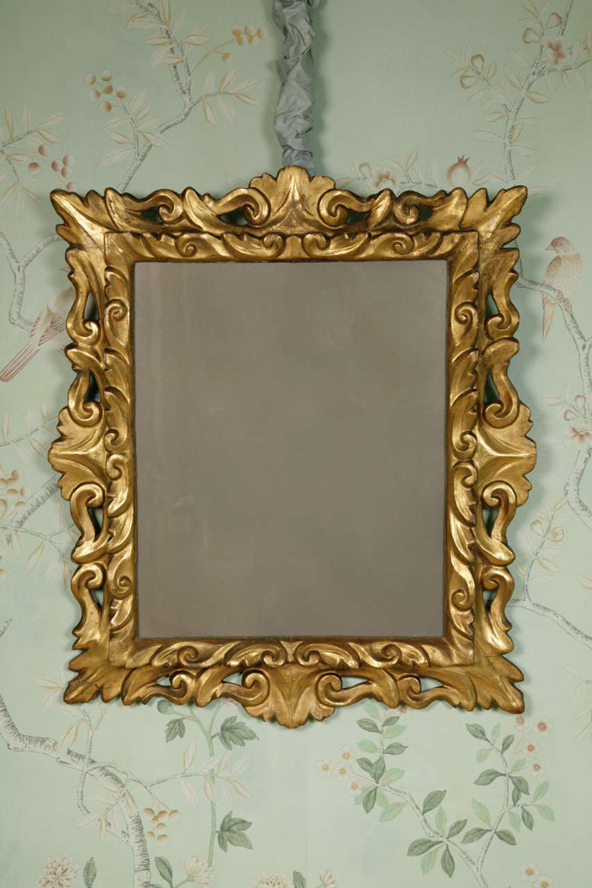 A carved and giltwood Italian mirror, circa 1740 with elaborate and flamboyant carving. Original gilding laid onto gesso. The central border standing proud of the larger border making an impressive three dimensional design.