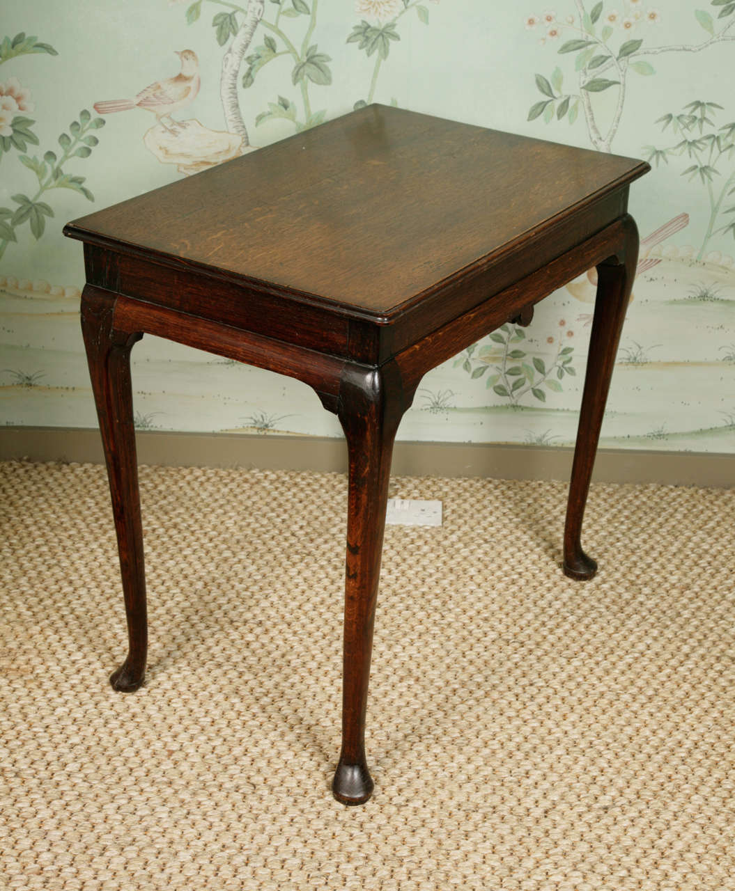 A charming small Georgian oak side table with a moulded edge top on a plain frieze with a central medallion. On cabriole legs with pad feet. The table dates from the first half of the 18th century. It has a nice patination, the top being somewhat