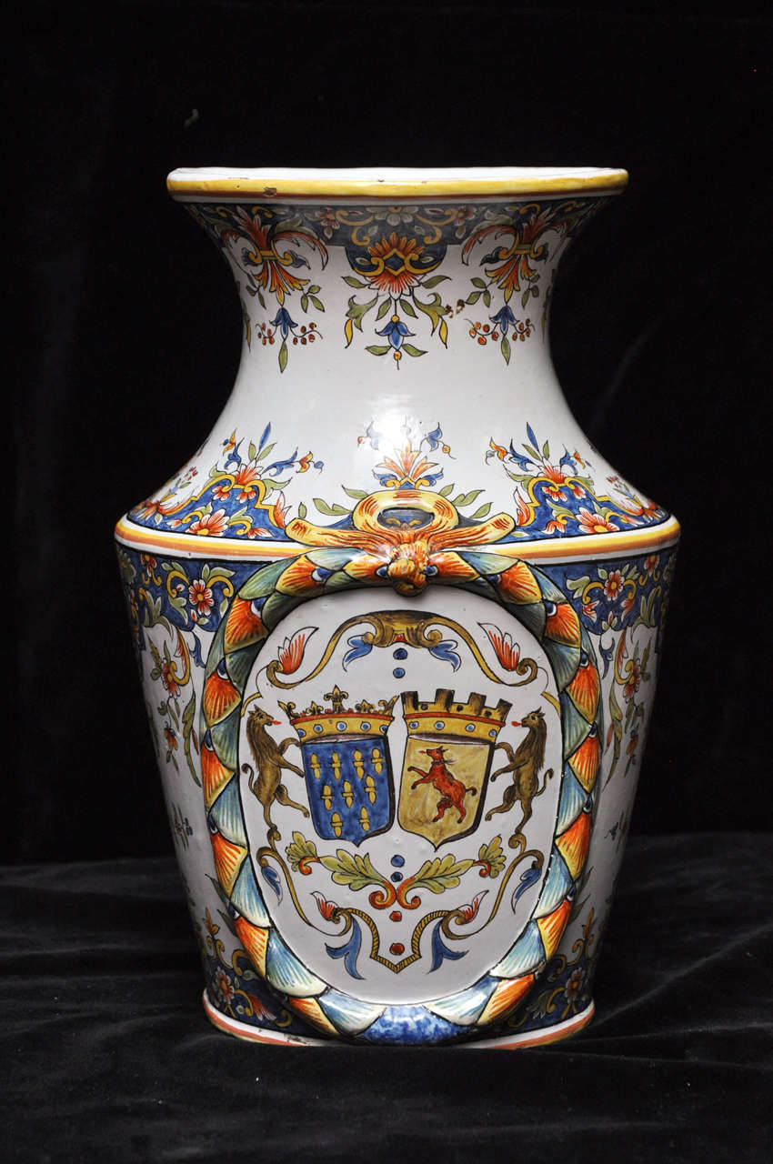An extraordinary pair of French faience vases hand-painted in the luxurious, polychrome, opaque tin glazes that made Rouen faience so famous. The delicate paisley pattern begins at the very top of the vase and continues down to the base, interrupted