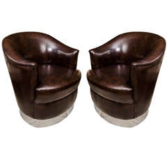 Pair of barrel back leather upholstered swiveling club chairs by Karl Springer