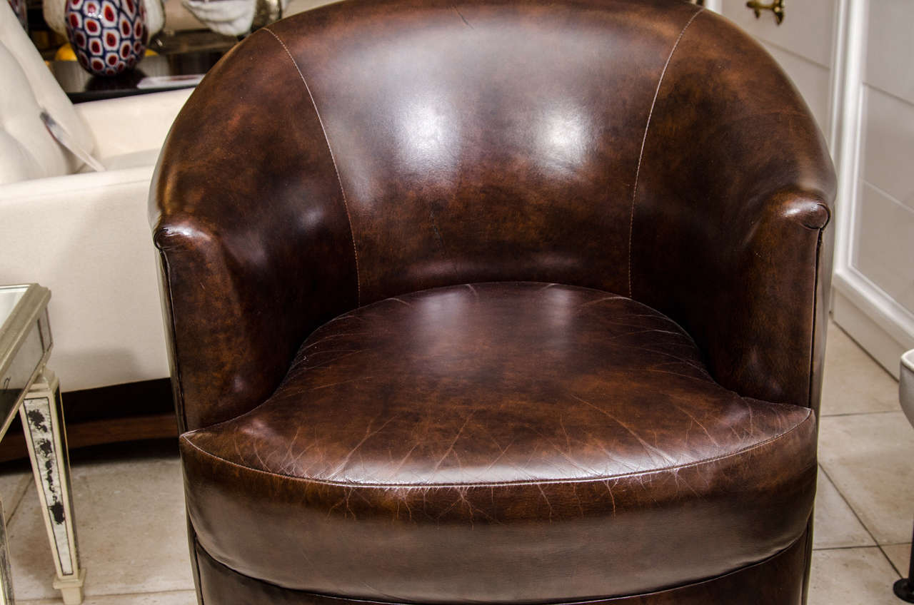 American Pair of barrel back leather upholstered swiveling club chairs by Karl Springer