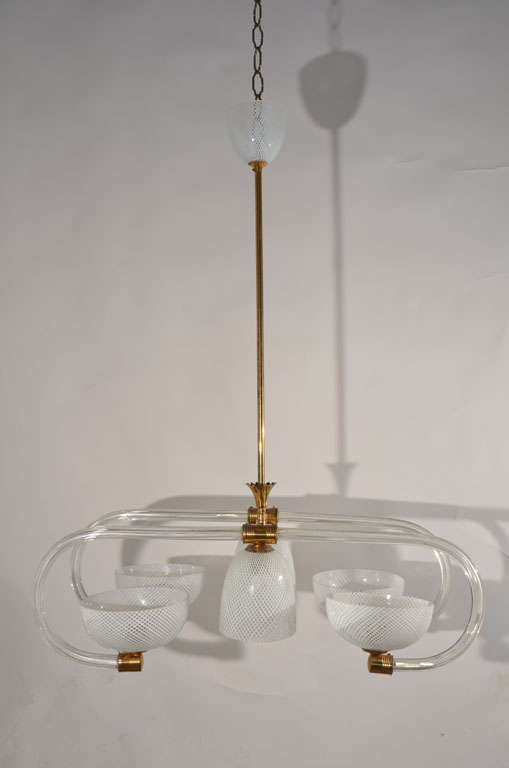 A Mid-Century Italian chandelier in blown Murano glass with a white and clear 'latticino' design. It features six lights, a latticino glass canopy, and polished brass fittings.