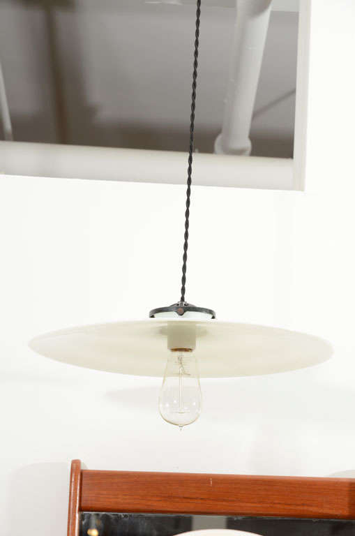 Vintage hanging milk glass light in a large 16-inch diameter size. USA circa 1920. Light features an original antique white milk glass disk shade with new bulb holder suspended on French black silk twist cord; includes Edison clear bulb and