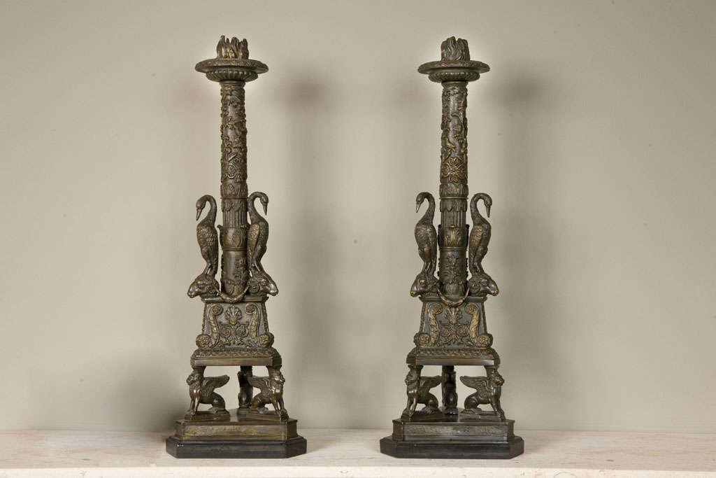 A pair of gilt bronze candlesticks of neo-classical form, probably English, 19th century, after a design by Giovanni Battista Piranesi and similar to the Newdigate candelabrum in the collection of the Ashmolean Museum, the columns with three cast