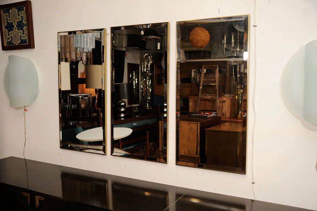 Beautiful set of three modern, bevelled mirrors with simple brass frames by La Barge. The measurements provided are for one mirror. The price is for the set. Please contact for location.