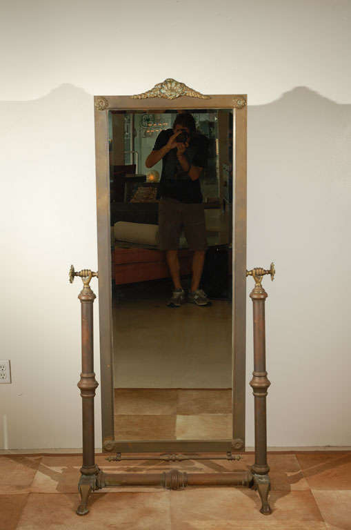 Gorgeous tilting brass cheval mirror in a decorative revival style.