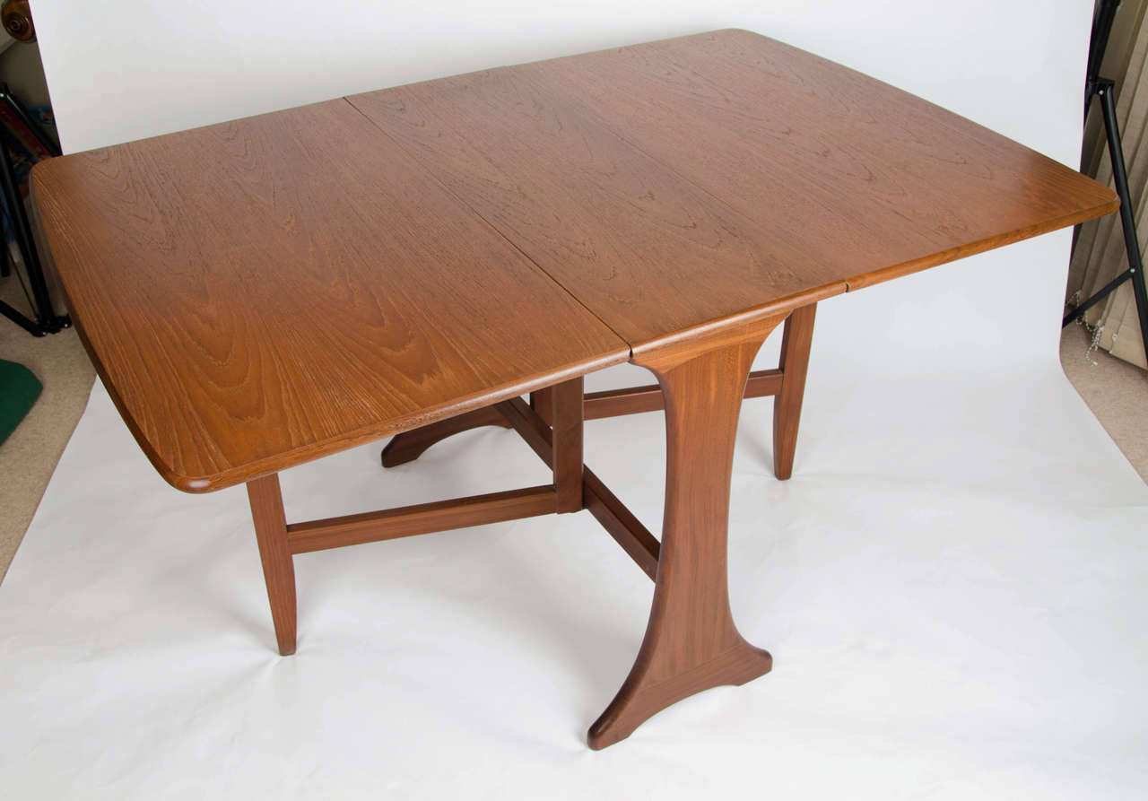 This is an original drop-leaf dining table by G-plan, England.

The table has a Classic leg shape with two folding leaves having slightly curved ends. This is a six seater dining table with both leaves out but is very adaptable by using one, two or