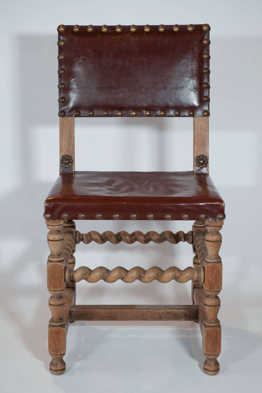 Set of 6- 20th Century Flemish Chairs  with turned wooden leg detailing and brass tacking, c. 1920 Belgium. Original Leather upholstery. Sold As Is