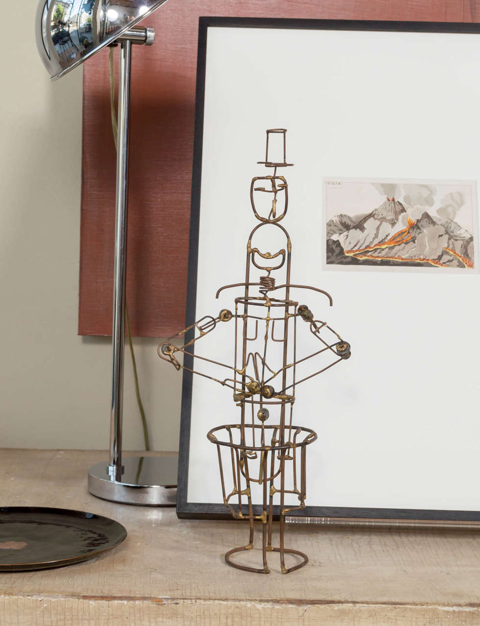 A figural wire Sculpture of what looks to be a chimney sweep with top hat that moves to raise and lower arms and jaw.