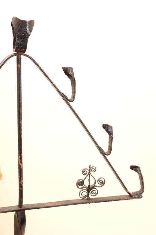 A Spanish cast iron candelabra with triangular top.