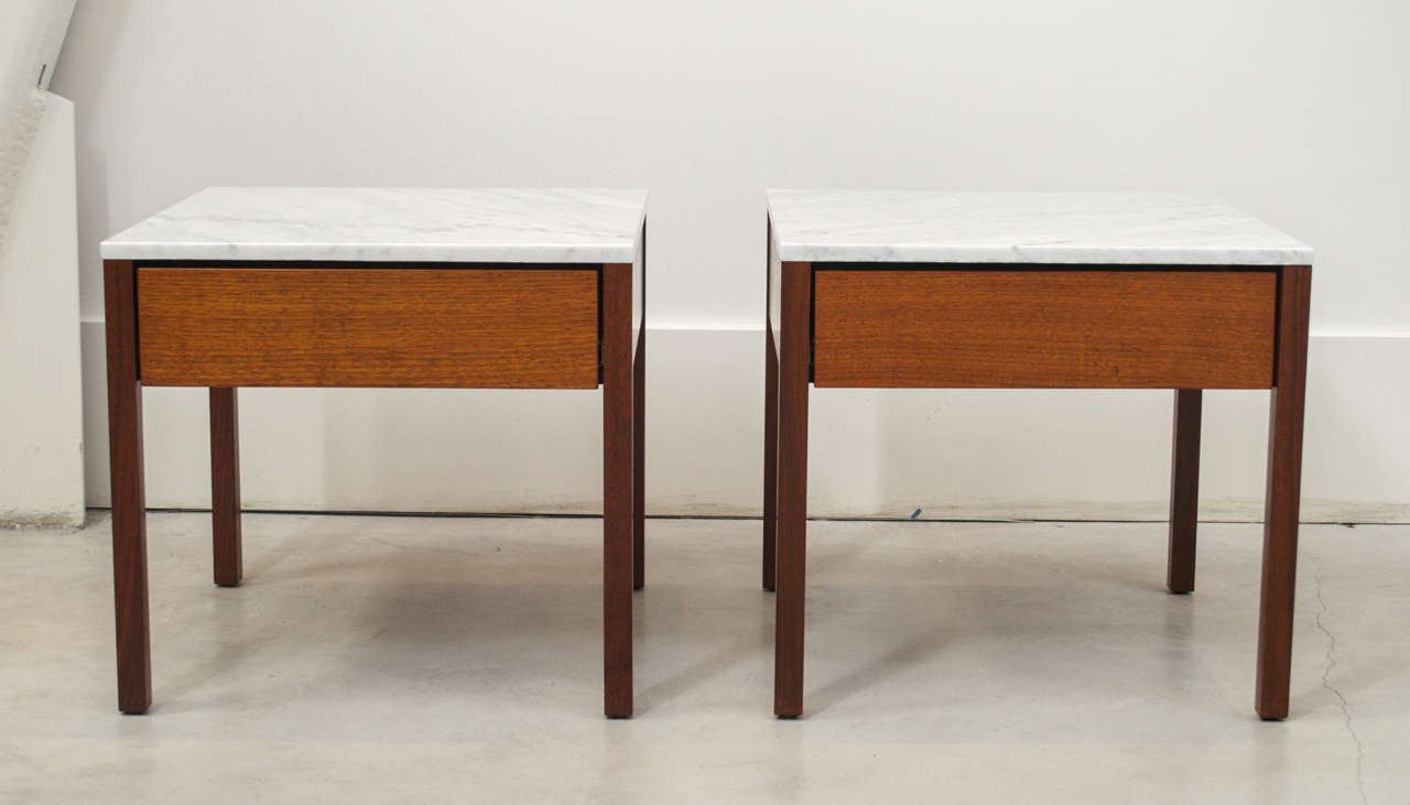 A pair of single-drawer side tables designed by Florence Knoll. Drawer and legs of walnut, top of white carrara marble; Manufacturer's fabric labels;
