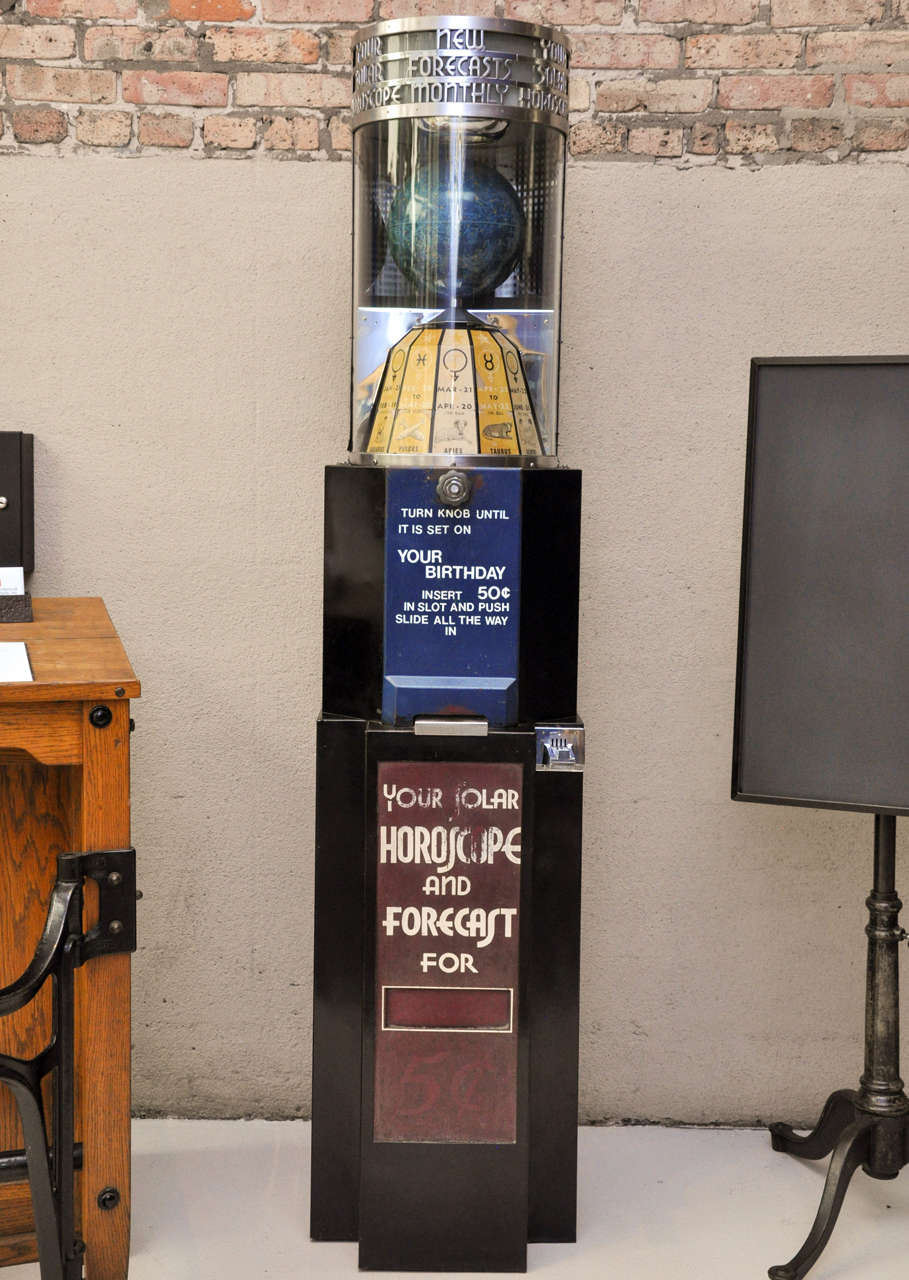 An American, circa 1940-1950, coin operated horoscope and forecast machine by Peerless Weighing and Vending Machine Corporation. By turning the nob the astrological chart and globe spin to select your zodiac sign.