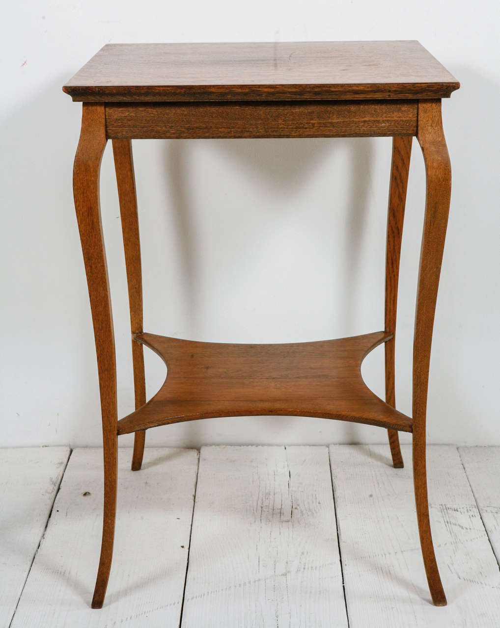 Square accent table with curved legs and diamond shelf.