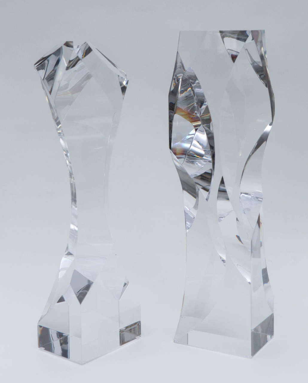 A sparkling duo of Lucite sculptures that are all angles and curves. Signed and dated  on the bottom 