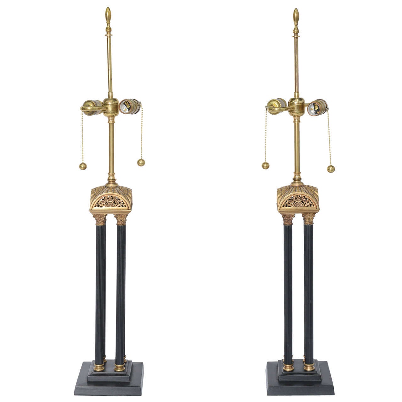 
Exquisite craftsmanship describes this pair of English neoclassical style table lamps with four Corinthian columns rising from a stepped plinth base to a stylized arched roof with reticulated and pierced scroll work. The stem rising to double