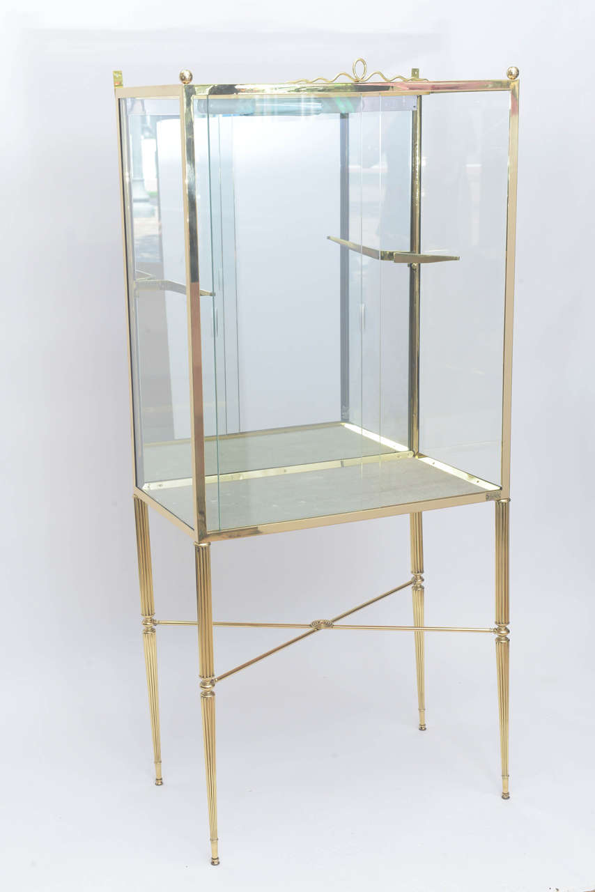 Beautifully designed display cabinet in brass and glass with adjustable single shelf not shown very much in the manner of Osvaldo Borsani. Illuminates from above.