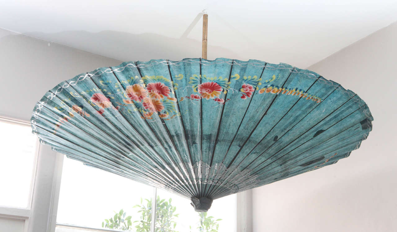 Turquoise blue coated paper large parasol with floral designs.